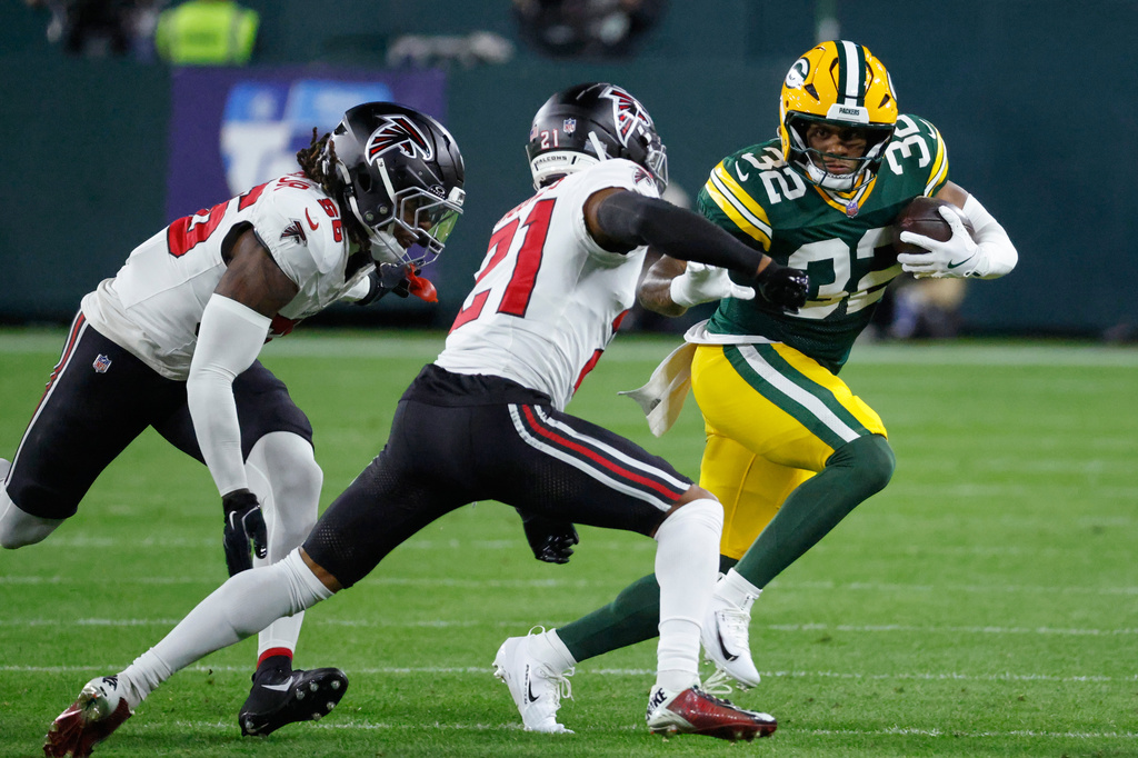 Green Bay Packers' Marshawn Lloyd tries to run past Atlanta Falcons' Mike Hughes during the first half of an NFL football game in Green Bay, Wis., Thursday, Sept. 24, 2026. (AP Photo/Mike Roemer)