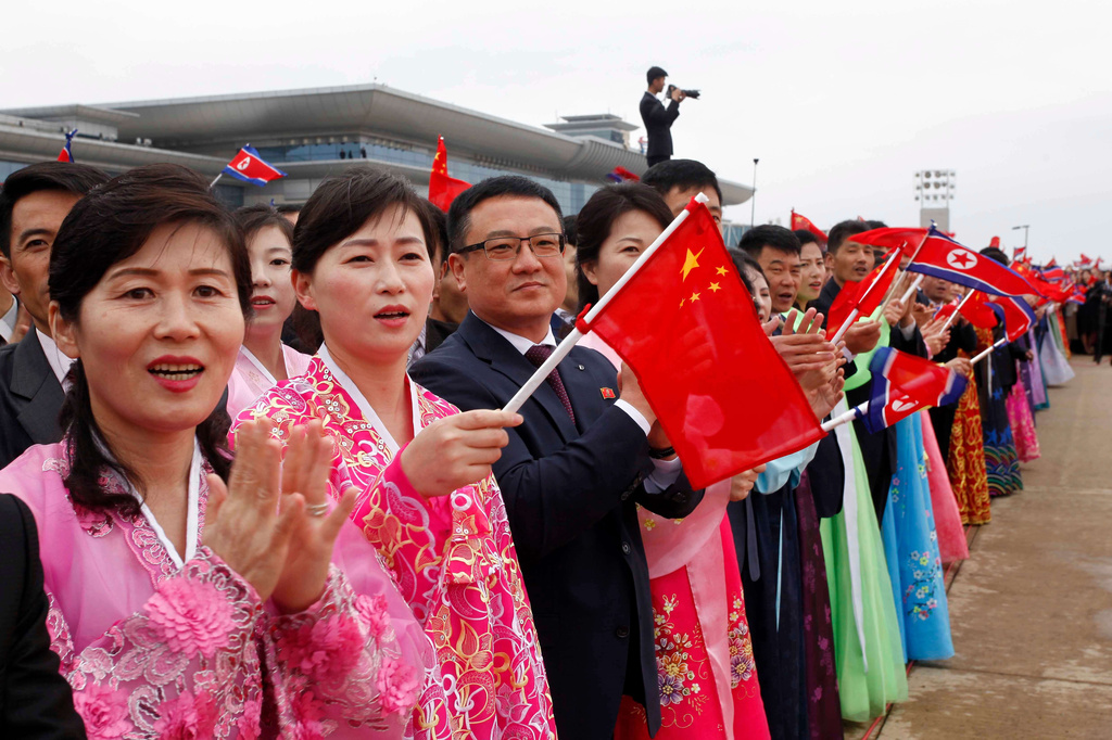 People welecom the arrival of Chinese Foreign Minister Wang Yi, unseen, at the Pyongyang International Airport in Pyongyang, North Korea Thursday, April 9, 2026. (AP Photo/Jon Chol Jin)