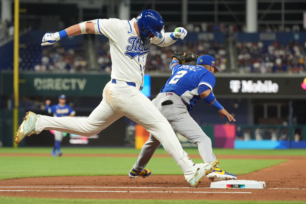 Venezuela first baseman Luis Arraez (2) catches the ball as Italy Vinnie Pasquantino is out on first base during the second inning of a World Baseball Classic semifinal game, Monday, March 16, 2026, in Miami. (AP Photo/Rebecca Blackwell)