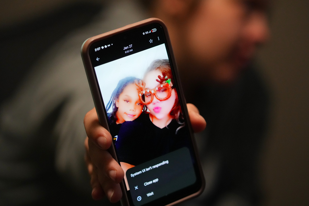 Cheyenne Hangaman shows a photograph of her and her son, Kaleb, 8, who along with his two brothers Howard, 6, and EJ, 9, drowned in a frozen pond Tuesday, Jan. 27, 2026, in Bonham, Texas. (AP Photo/Julio Cortez)