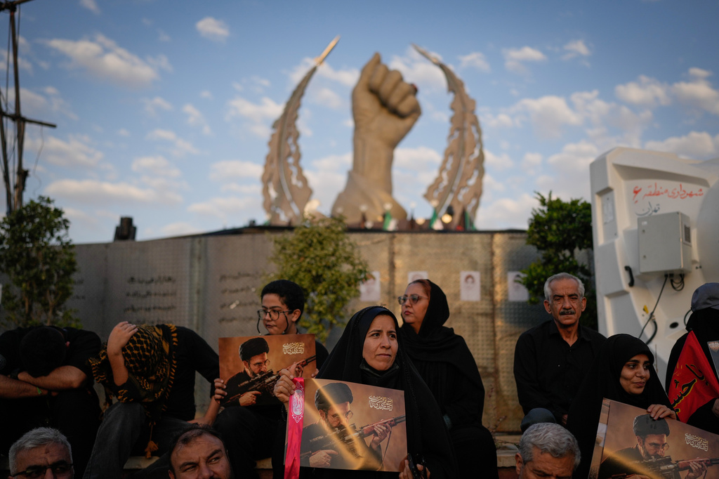Mourners hold portraits of Iran's new Supreme Leader Mojtaba Khamenei while gathered in Islamic Revolution Square for the funeral procession of the slain Iranian Supreme Leader Ayatollah Ali Khamenei in Tehran, Iran, Monday, July 6, 2026. (AP Photo/Altaf Qadri)