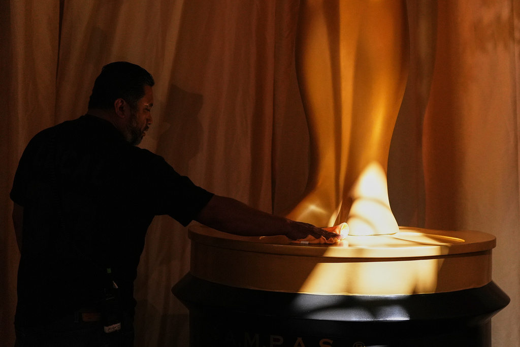 Alex Cortez polishes the base of an Oscar statue at the Dolby Theatre in Los Angeles, Saturday, March 14, 2026, in preparation for Sunday's 98th Academy Awards ceremony. (AP Photo/Gregory Bull)