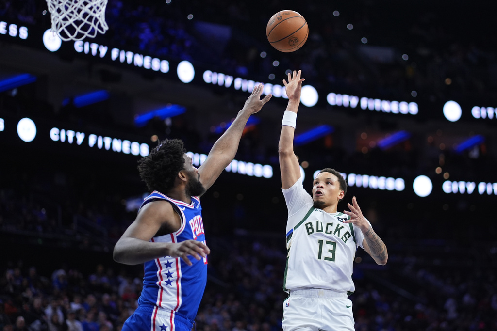 Milwaukee Bucks' Ryan Rollins, right, goes up for a shot against Philadelphia 76ers' Joel Embiid during the first half of an NBA basketball game Tuesday, Jan. 27, 2026, in Philadelphia. (AP Photo/Matt Slocum)