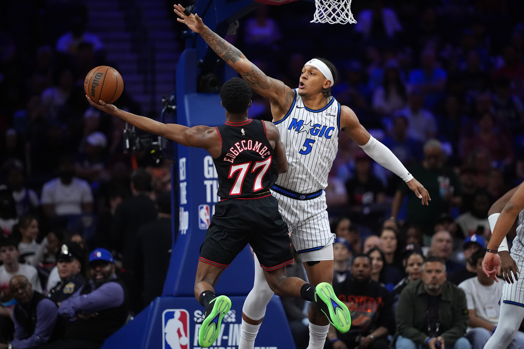 Philadelphia 76ers' Vj Edgecombe, left, goes up for a shot against Orlando Magic's Paolo Banchero during the first half of an NBA play-in tournament basketball game Wednesday, April 15, 2026, in Philadelphia. (AP Photo/Matt Slocum)