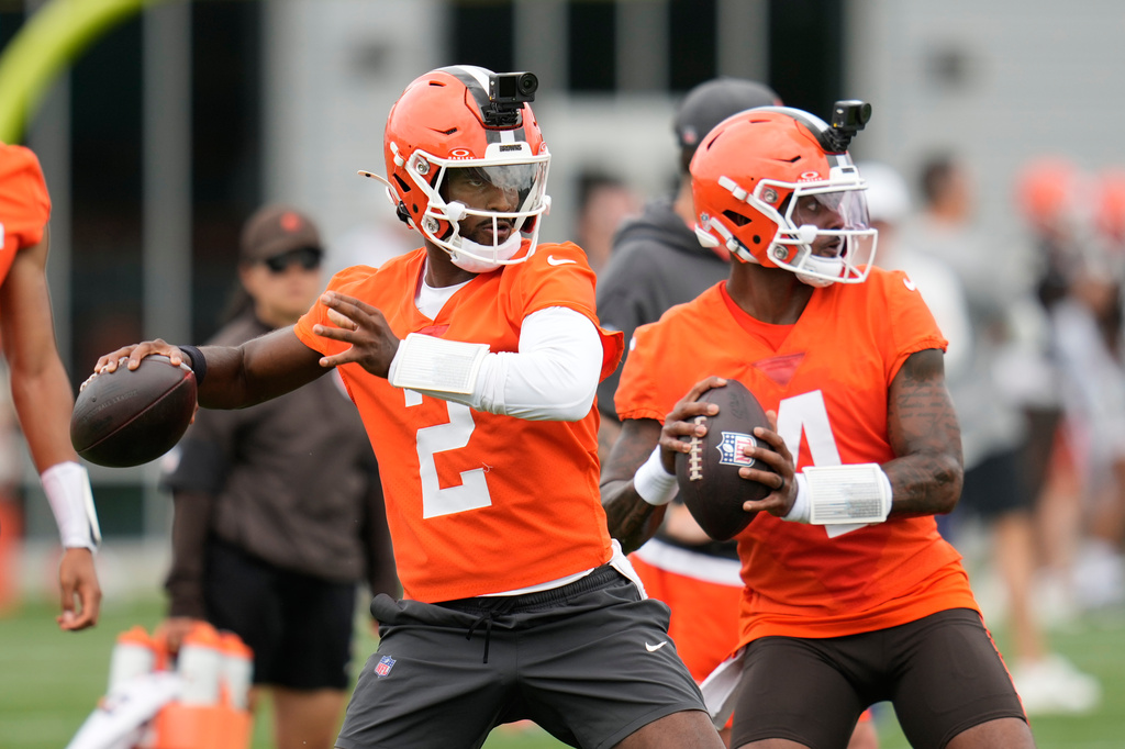 FILE - Cleveland Browns quarterbacks Shedeur Sanders, left, and Deshaun Watson, right, throw during the teams' NFL football practice, Tuesday, June 9, 2026, in Berea, Ohio. (AP Photo/Sue Ogrocki, File)