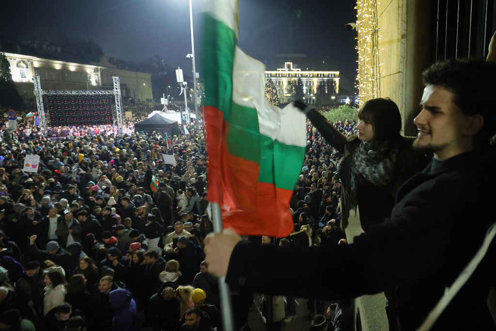 Students wave Bulgarian flag as as a swelling crowd of tens of thousands of Bulgarians filled Sofia's central square, demanding the government's resignation amid rising anger over corruption and contested economic policies, Sofia, Bulgaria, Wednesday, Dec. 10, 2025. (AP Photo/Valentina Petrova)