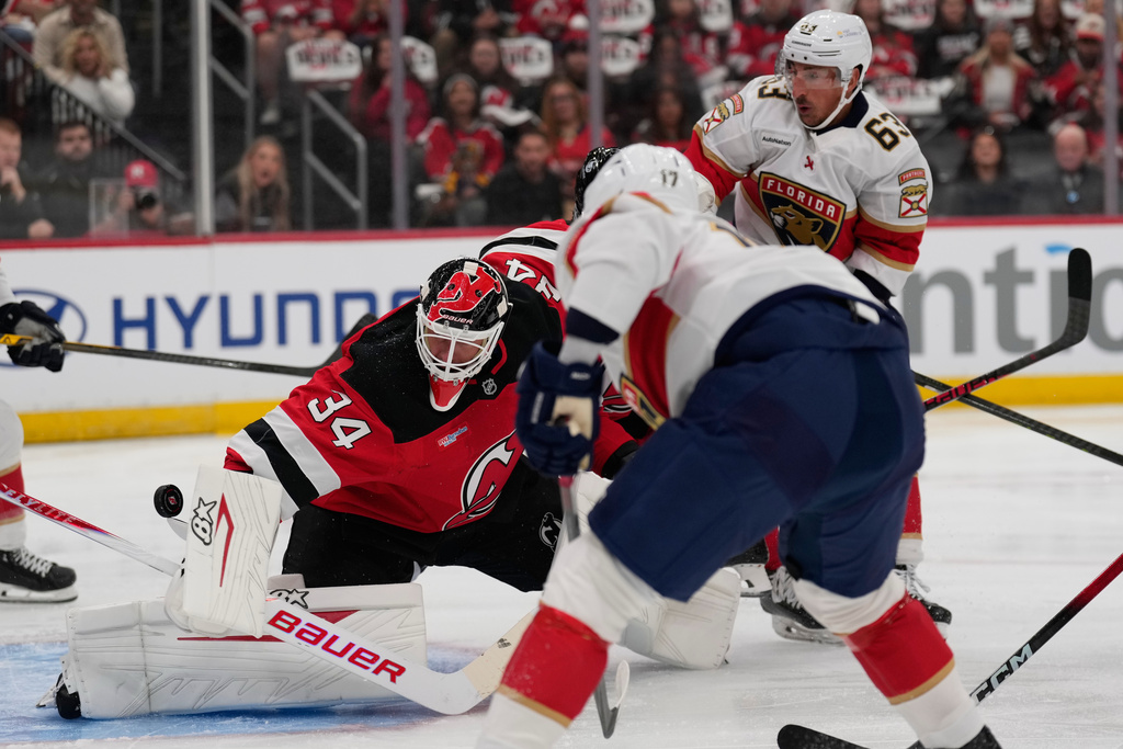 Florida Panthers' Evan Rodrigues, foreground, scores a goal past New Jersey Devils goaltender Jake Allen (34), left, during the first period of an NHL hockey game Thursday, Oct. 16, 2025, in Newark, N.J. (AP Photo/Seth Wenig)