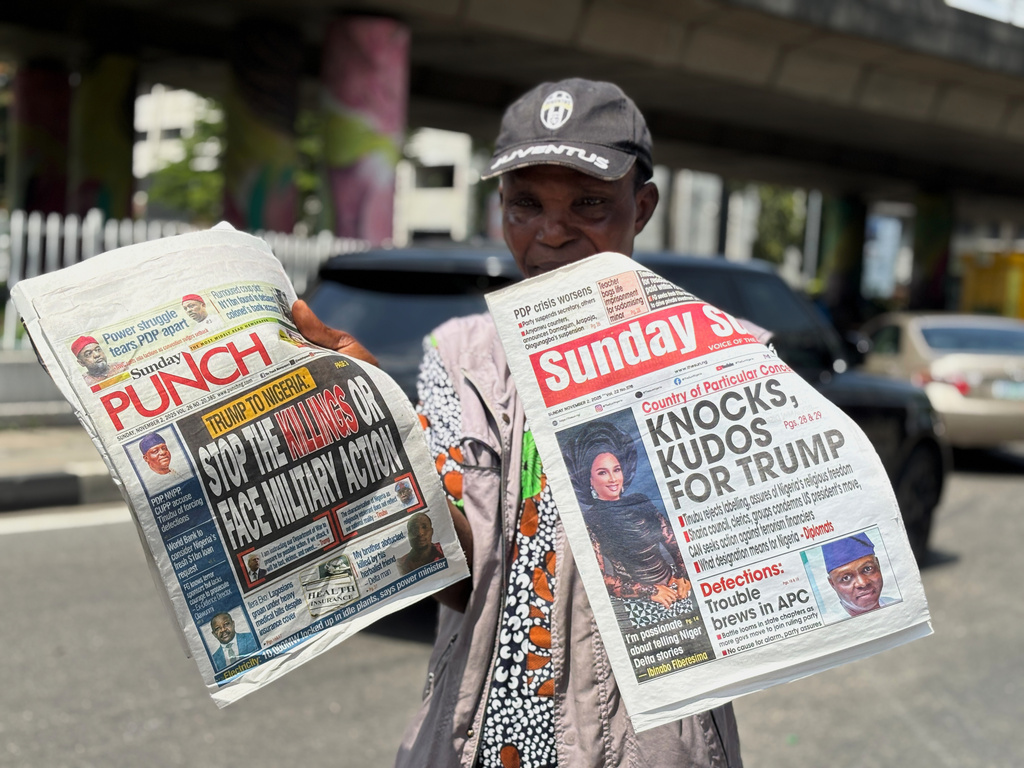 A vendor sells local newspapers with headlines referring to US President Donald Trump's comments about Nigeria, on the street of Lagos, Nigeria, Sunday, Nov. 2, 2025. (AP Photo/Sunday Alamba)