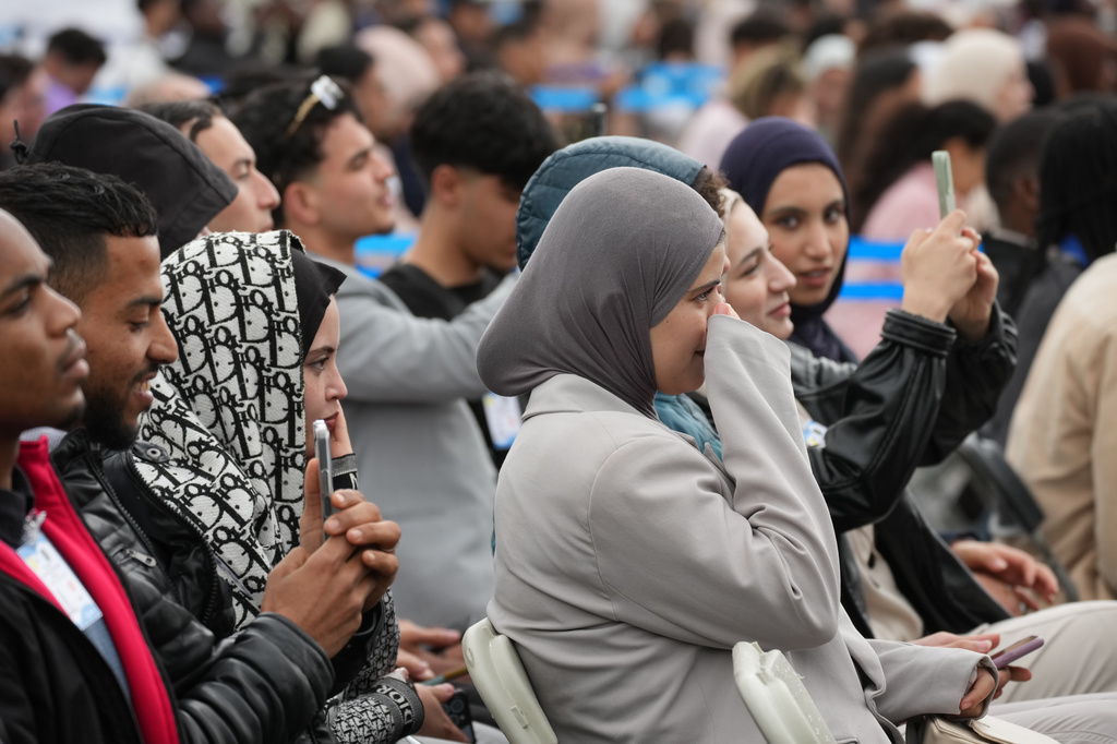People gather to watch Pope Leo XIV arriving at Maqam Echahid Martyrs' Monument in Algiers, Monday, April 13, 2026, on the first day of an 11-day apostolic journey to Africa. (AP Photo/Andrew Medichini)
