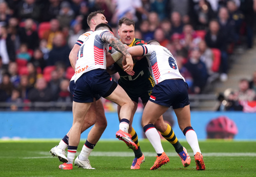 Australia's Angus Crichton (centre) is tackled by England's John Bateman (left) and George Williams during the rugby league match betwen England and Australia, at Wembley Stadium, London, Saturday Oct. 25, 2025. (Mike Egerton/PA via AP) Australia's Angus Crichton (centre) is tackled by England's John Bateman (left) and George Williams during the rugby league match betwen England and Australia, at Wembley Stadium, London, Saturday Oct. 25, 2025. (Mike Egerton/PA via AP)