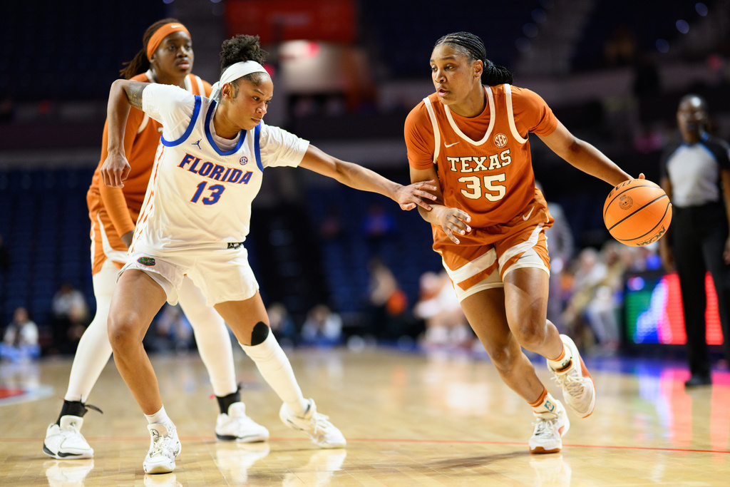 Texas forward Madison Booker (35) drives against Florida guard Laila Reynolds (13) during the first half of an NCAA college basketball game, Thursday, Jan. 29, 2026, in Gainesville, Fla. (AP Photo/Noah Lantor)