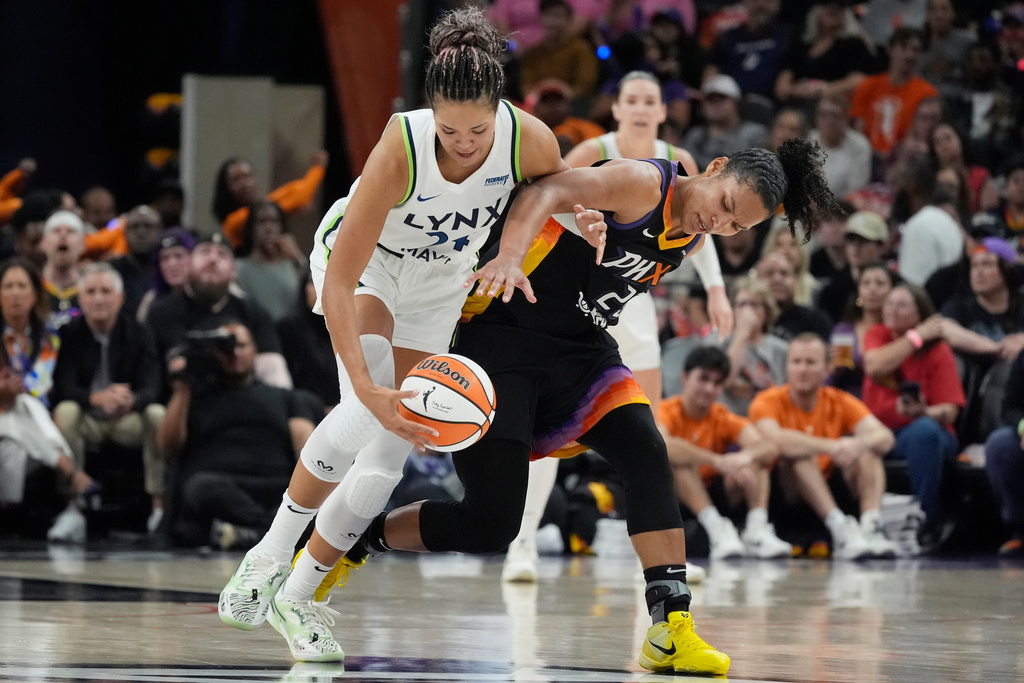 Minnesota Lynx forward Napheesa Collier, left, steals the ball from Phoenix Mercury forward Alyssa Thomas during the first half of Game 3 of a WNBA basketball playoff semifinals series game Friday, Sept. 26, 2025, in Phoenix. (AP Photo/Ross D. Franklin)