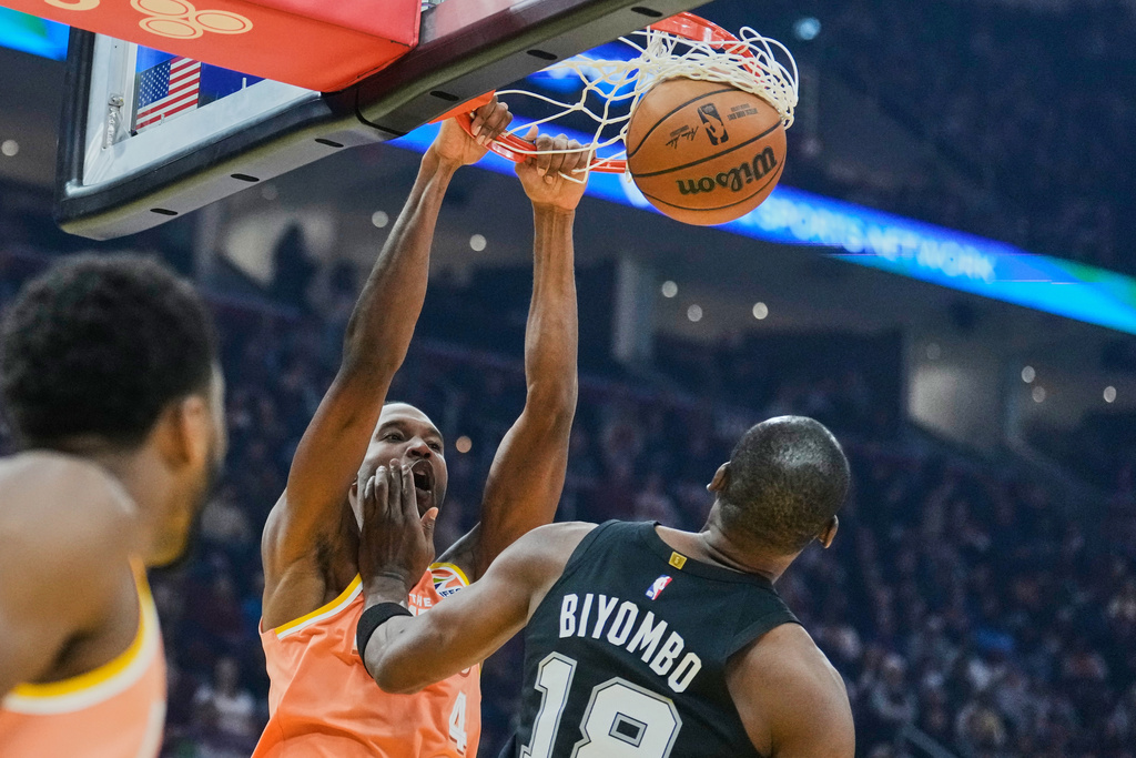 Cleveland Cavaliers center Evan Mobley (4) dunks over San Antonio Spurs center Bismack Biyombo (18) in the fist half of an NBA basketball game Friday, Dec. 5, 2025, in Cleveland. (AP Photo/Sue Ogrocki)