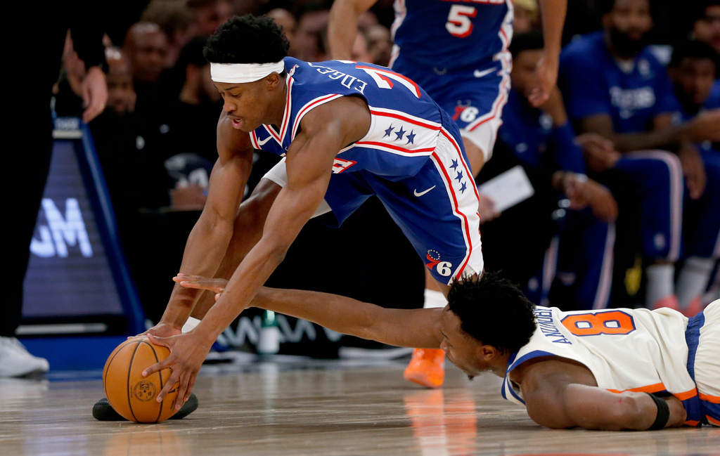Philadelphia 76ers guard VJ Edgecombe, left, and New York Knicks forward OG Anunoby, right, battle for a loose ball during the first half of an NBA basketball game, Saturday, Jan. 3, 2026, in New York. (AP Photo/John Munson)