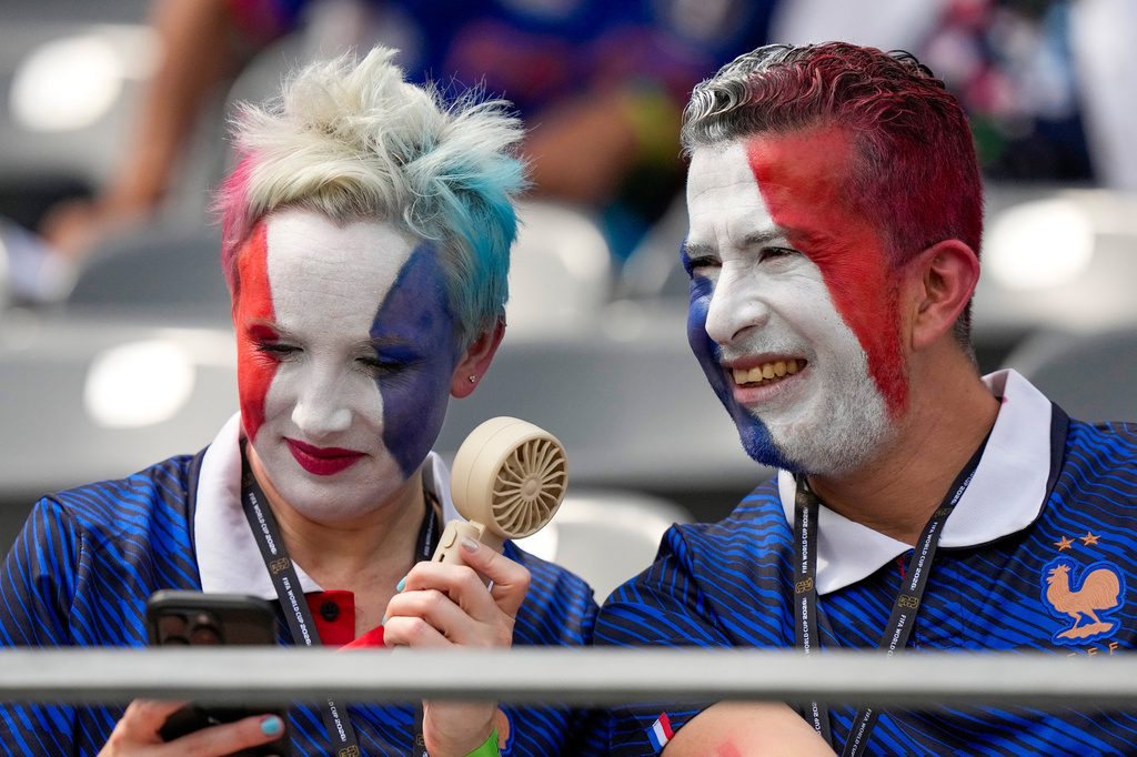 France supporters cool down with a fan before the World Cup round of 32 soccer match between France and Sweden in East Rutherford, N.J., near New York, Tuesday, June 30, 2026. (AP Photo/Frank Franklin II)