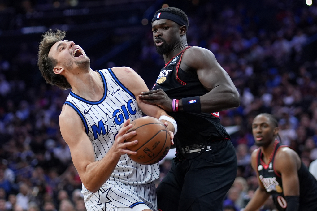 Orlando Magic's Franz Wagner, left, is fouled by Philadelphia 76ers' Adem Bona during the first half of an NBA play-in tournament basketball game Wednesday, April 15, 2026, in Philadelphia. (AP Photo/Matt Slocum)