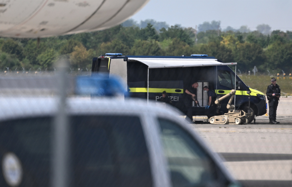 Police forensic technicians prepare to deploy an explosive-disposal robot near a Ukrainian aircraft at Leipzig/Halle Airport, in Schkeuditz, Germany, Wednesday Aug. 5, 2026, where flight operations were suspended overnight after a drone sighting was reported and another object was found near a runway. (Hendrik Schmidt/dpa via AP)