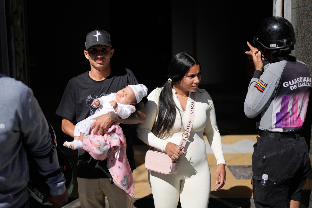 Tito Martinez, a Venezuelan migrant sent by the U.S. to El Salvador and later deported to Venezuela, walks with his family after reading a statement at a government building in Caracas, Venezuela, Friday, Dec. 26, 2025. (AP Photo/Matias Delacroix)