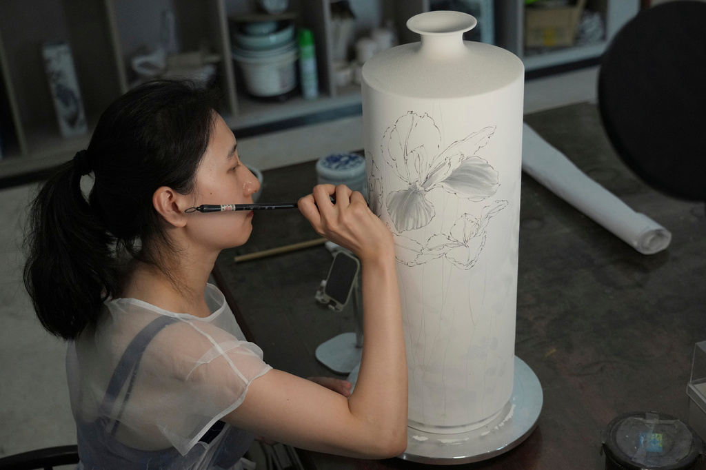 Chinese porcelain artist Chen Qing paints a vase in Jingdezhen, known as China's "Porcelain Capital," in eastern China's Jiangxi province, Tuesday, Sept. 1, 2026. (AP Photo/Achmad Ibrahim)