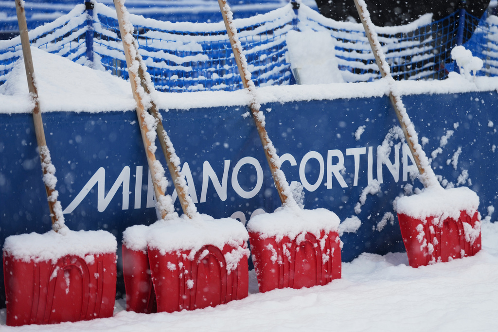 Heavy snow falls on shovels during a weather delay before the women's freestyle skiing halfpipe final at the 2026 Winter Olympics, in Livigno, Italy, Saturday, Feb. 21, 2026. (AP Photo/Lindsey Wasson)