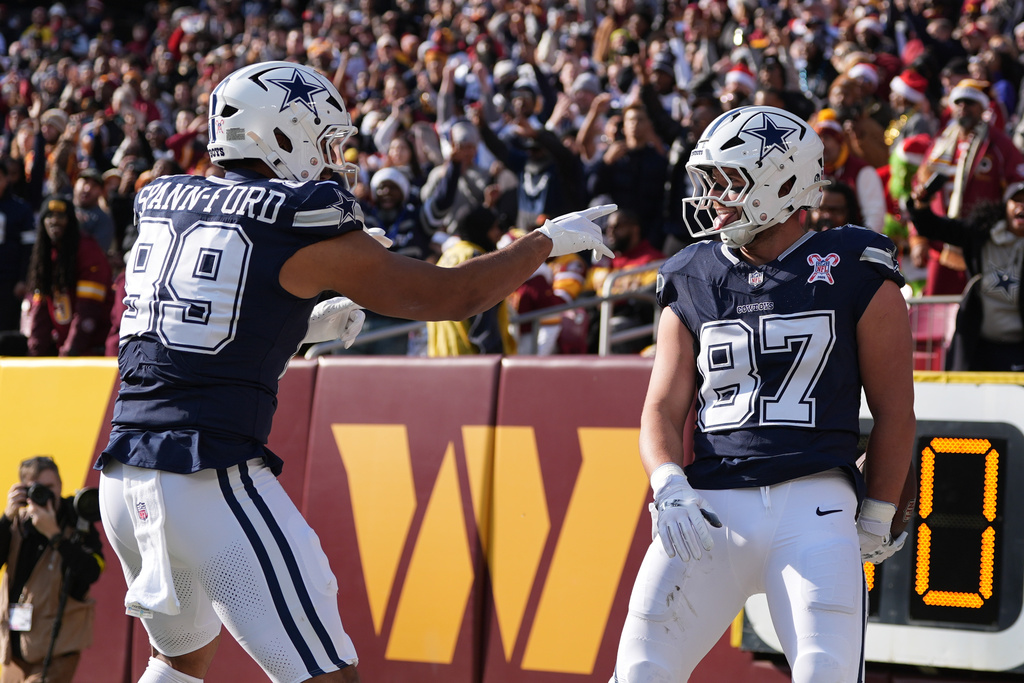 Dallas Cowboys tight end Jake Ferguson (87) is congratulated by teammate defensive tackle Perrion Winfrey (99) after catching a touchdown pass during the first half an NFL football game against the Washington Commanders Thursday, Dec. 25, 2025, in Landover, Md. (AP Photo/Stephanie Scarbrough)