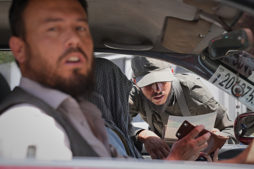 A Taliban security officer checks a driver's identification at a checkpoint ahead of celebrations marking the fifth anniversary of the U.S. withdrawal from Afghanistan and the start of Taliban rule, in Kabul, Afghanistan, Thursday, Aug. 13, 2026. (AP Photo/Siddiqullah Alizai)
