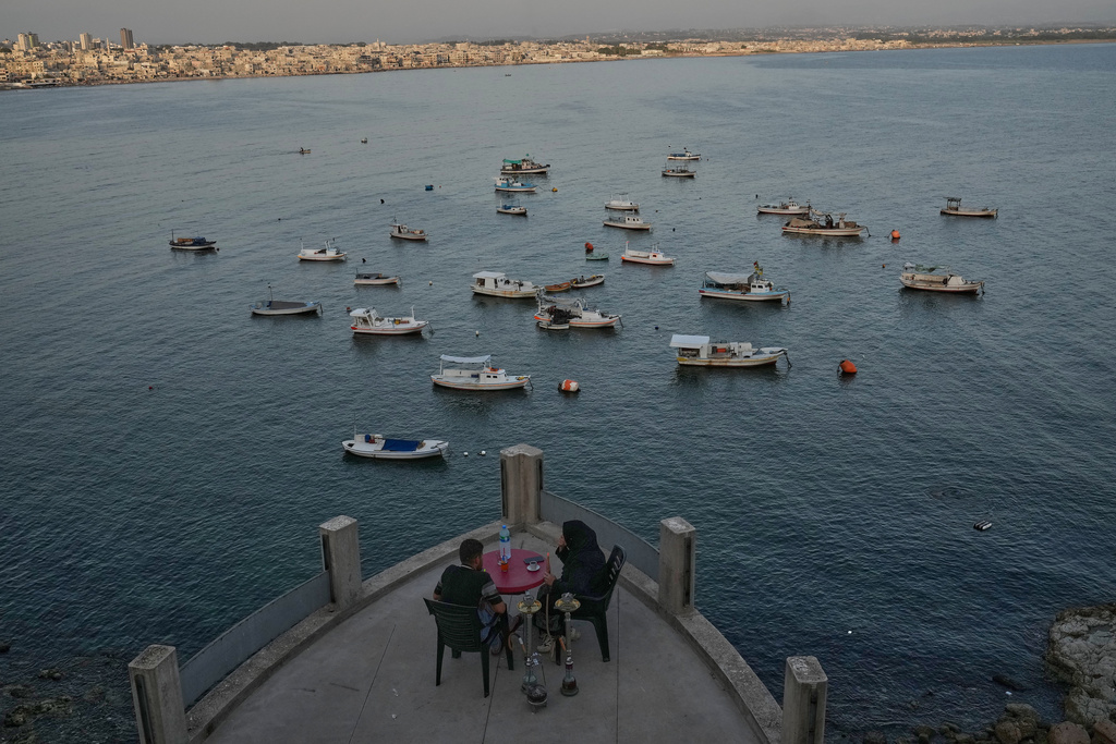 A Syrian couple smoke "shisha" water pipe at Latakia's Mediterranean seaside corniche, in the coastal city of Latakia, Syria, Saturday, Oct. 4, 2025. (AP Photo/Hussein Malla)