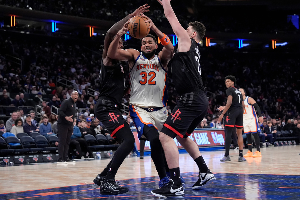New York Knicks center Karl-Anthony Towns (32) drives past Houston Rockets forward Tari Eason (17) and Houston Rockets center Alperen Sengun (28) during the second half of an NBA basketball game, Saturday, Feb. 21, 2026, in New York. (AP Photo/Yuki Iwamura)
