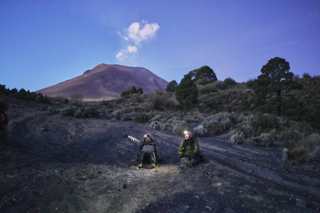 FILE - Marco Calo, left, a geophysicist at the National Autonomous University of Mexico (UNAM), takes a break on the slopes of the Popocatepetl volcano in Mexico, Dec. 5, 2025. (AP Photo/Eduardo Verdugo, File)