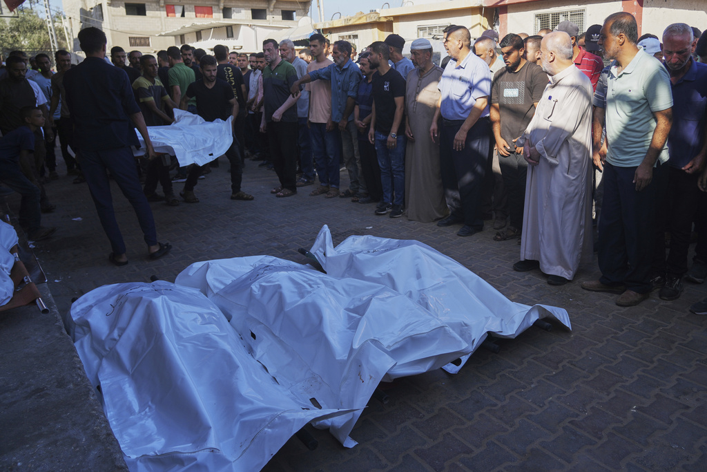 Palestinians carry the body of a family member killed in an Israeli military strike as they gather outside Al-Aqsa Hospital in Deir al-Balah, in the central Gaza Strip, Monday, Sept. 1, 2025. (AP Photo/Abdel Kareem Hana)