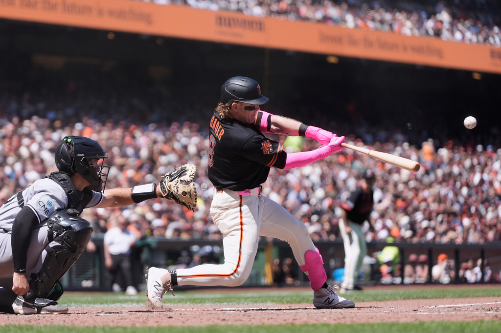 San Francisco Giants' Harrison Bader, right, hits a grand slam next to Chicago White Sox catcher Drew Romo during the fifth inning of a baseball game Saturday, May 23, 2026, in San Francisco. (AP Photo/Jeff Chiu)