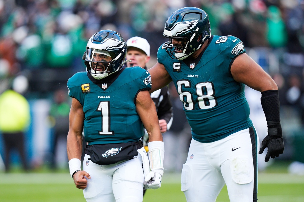 Philadelphia Eagles quarterback Jalen Hurts (1) and Eagles offensive tackle Jordan Mailata (68) celebrate the touchdown of Eagles wide receiver A.J. Brown during the second half of an NFL football game against the Las Vegas Raiders on Sunday, Dec. 14, 2025, in Philadelphia. (AP Photo/Chris Szagola)