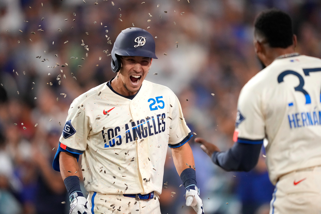 Los Angeles Dodgers' Tommy Edman, left, has seeds thrown at him by Teoscar Hernández after hitting a three-run home run during the seventh inning of a baseball game against the Washington Nationals, Saturday, Sept. 5, 2026, in Los Angeles. (AP Photo/Mark J. Terrill)