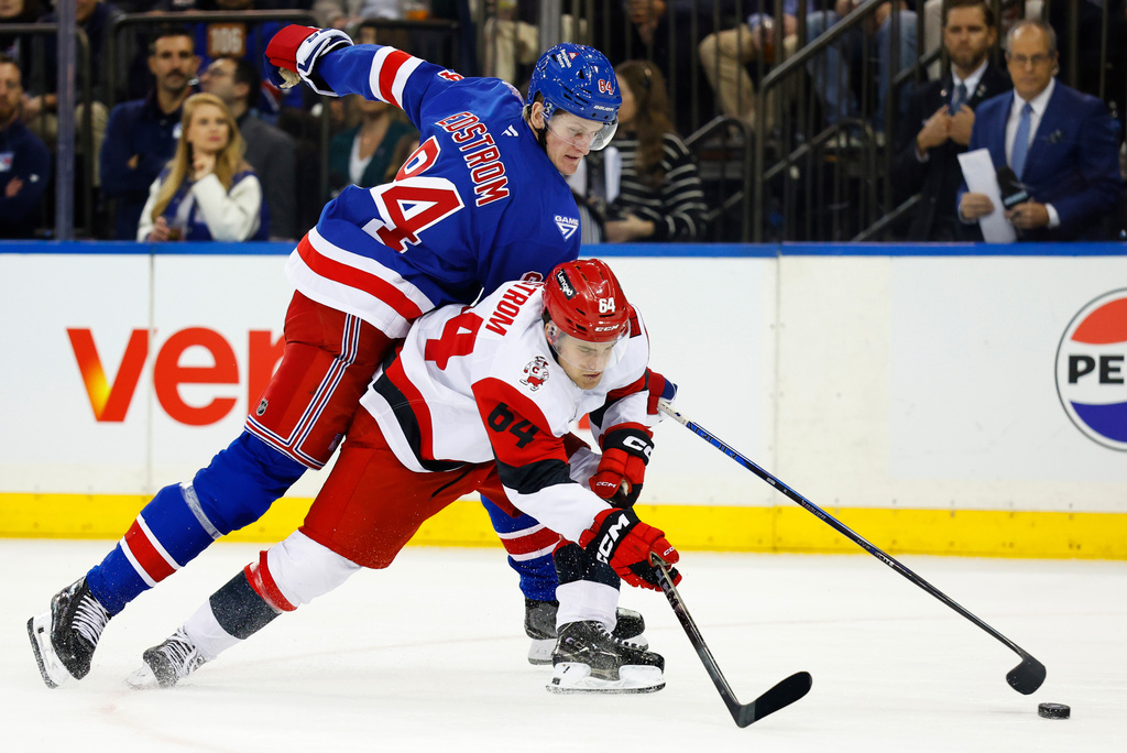 New York Rangers center Adam Edstrom and Carolina Hurricanes defenseman Joel Nystrom battle for the puck during the second period of an NHL hockey game, Tuesday Nov. 4, 2025, in New York. (AP Photo/Noah K. Murray)