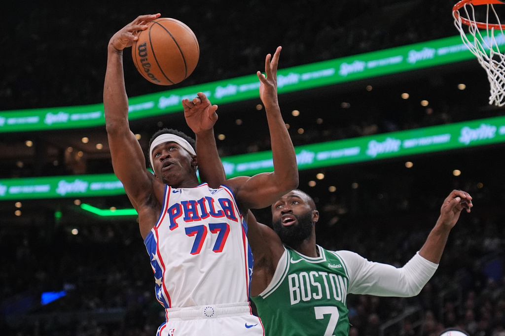 Philadelphia 76ers guard Vj Edgecombe (77) grabs a rebound against Boston Celtics guard Jaylen Brown (7) during the second half of Game 2 of a first-round NBA playoffs basketball series, Tuesday, April 21, 2026, in Boston. (AP Photo/Charles Krupa)