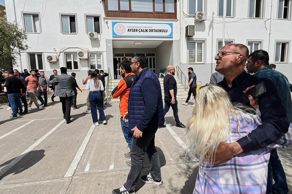 People stand at the courtyard of a secondary school where an assailant opened fire, in Kahramanmaras, Turkey, Wednesday, April 15, 2026, (IHA via AP)