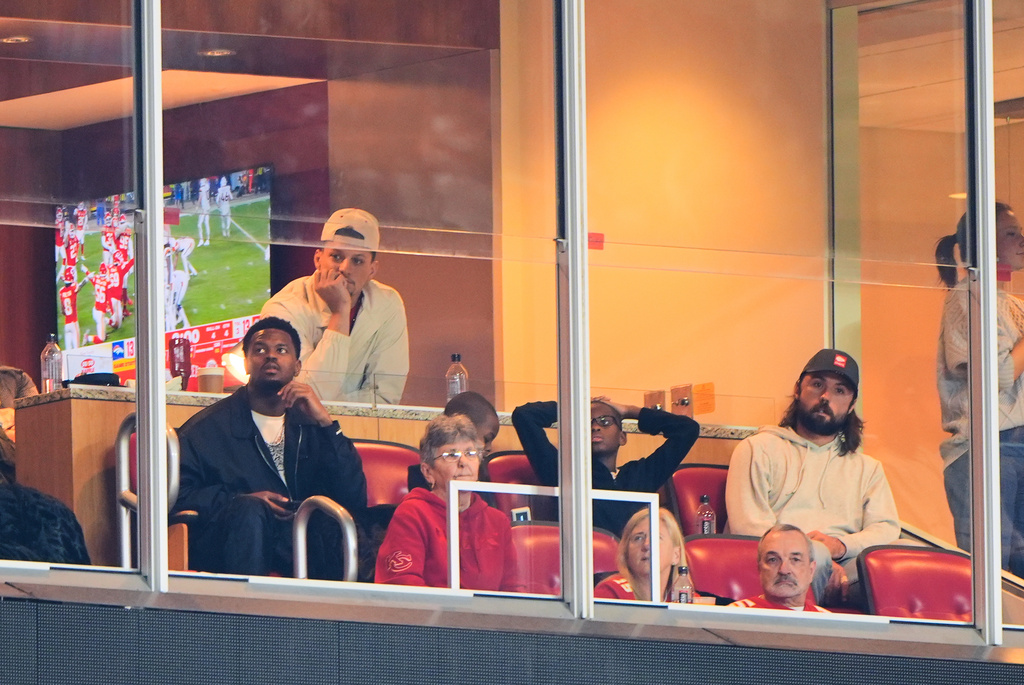 Injured Kansas City Chiefs quarterbacks Patrick Mahomes, top, and Gardner Minshew, right, watch from a suite during the second half of an NFL football game against the Denver Broncos, Thursday, Dec. 25, 2025, in Kansas City, Mo. (AP Photo/Charlie Riedel)