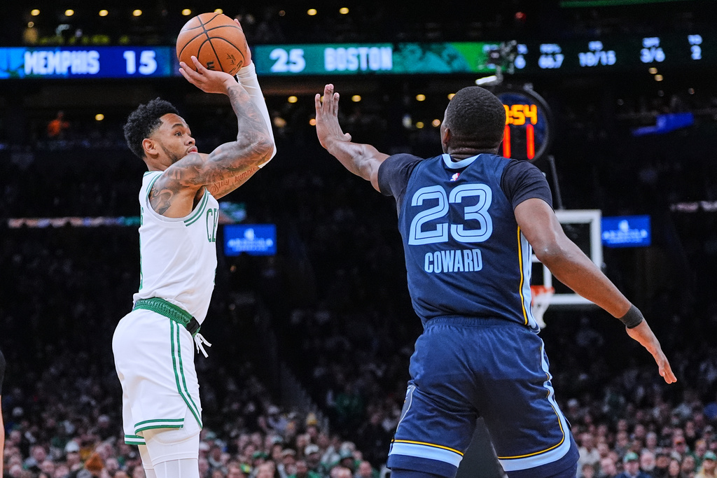 Boston Celtics guard Anfernee Simons, left, takes a 3-point shot against Memphis Grizzlies guard Cedric Coward (23) during the first half of an NBA basketball game, Wednesday, Nov. 12, 2025, in Boston. (AP Photo/Charles Krupa)