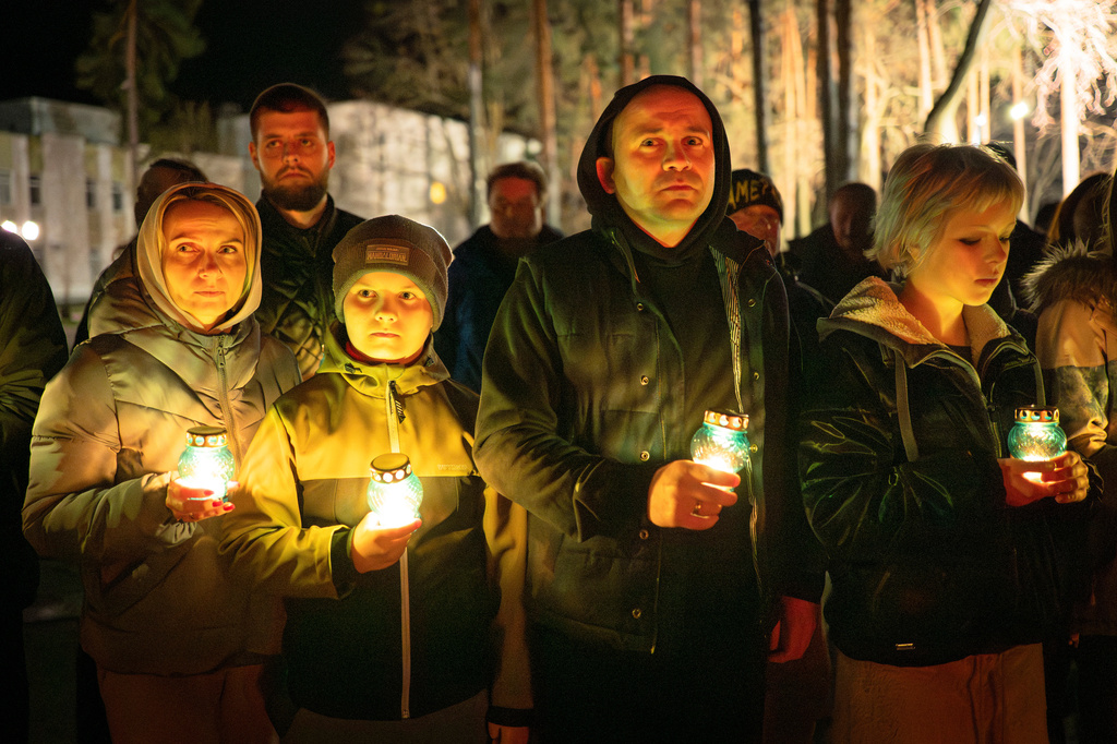 People bring candles at a memorial dedicated to firefighters and workers who died after the 1986 Chornobyl (Chernobyl) nuclear disaster, ahead of its 40th anniversary in Slavutych, Ukraine, Saturday, April 25, 2026. Chornobyl is the Ukrainian name for the city. (AP Photo/Dan Bashakov)