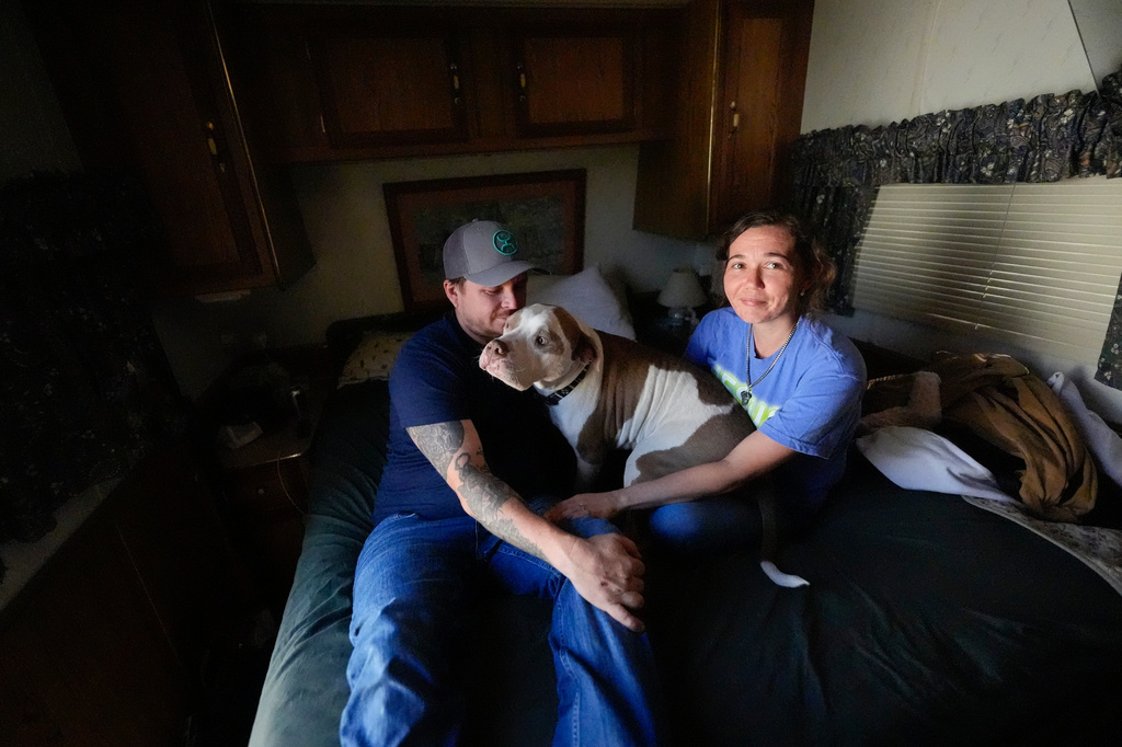 Michael Gibson and his fiancée Tabitha Enke sit inside their camper after losing their home during the Brantley Highway 82 fire, Friday, April 24, 2026, in Nahunta, Ga. (AP Photo/Mike Stewart)