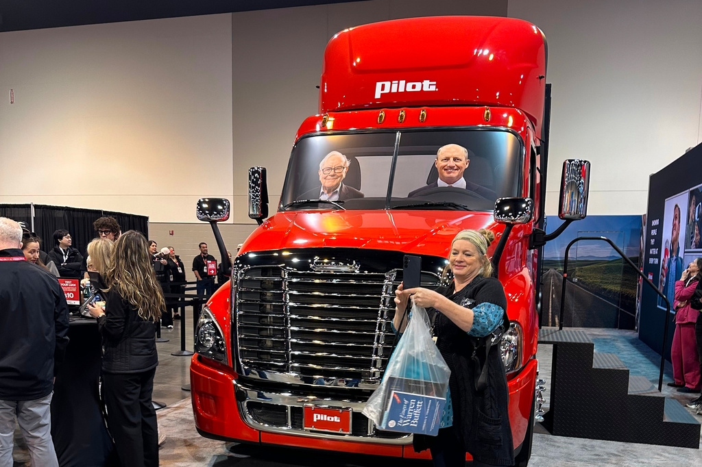 A Berkshire Hathaway shareholder takes a selfie in front of a Pilot truck stops semi truck with pictures of Berkshire's top two executives behind the wheel: new CEO Greg Abel and Chairman Warren Buffett on Friday, May 1, 2026 in Omaha, Neb. (AP Photo/Josh Funk)