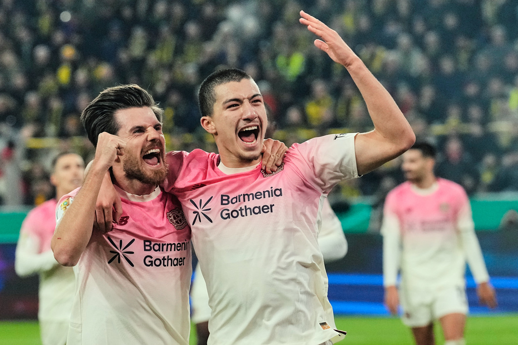 Leverkusen's Ibrahim Maza, right, celebrates with Leverkusen's Jonas Hofmann, left, after scoring the opening goal during the German Soccer Cup round of sixteen soccer match between Borussia Dortmund and Bayer 04 Leverkusen in Dortmund, Germany, Tuesday, Dec. 2, 2025. (AP Photo/Martin Meissner)