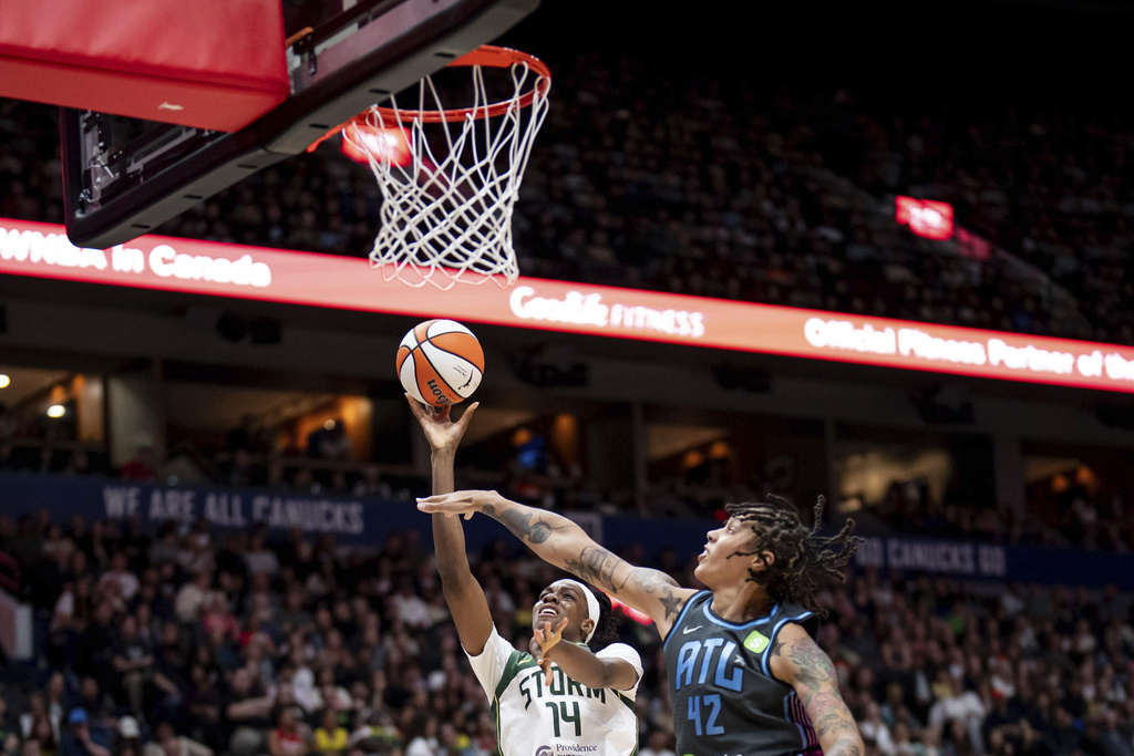 Seattle Storm's Dominique Malonga (14) lays up as Atlanta Dream's Brittney Griner (42) defends during the first half of a WNBA basketball game in Vancouver, British Columbia, on Friday, Aug. 15, 2025. (Ethan Cairns/The Canadian Press via AP)