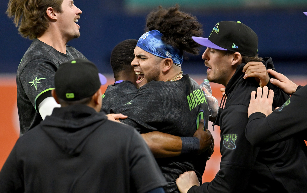 Tampa Bay Rays celebrate after Jonathan Aranda's, center, RBI walk-off single during the tenth inning of a baseball game against the New York Yankees Saturday, April 11, 2026, in St. Petersburg, Fla. (AP Photo/Jason Behnken)