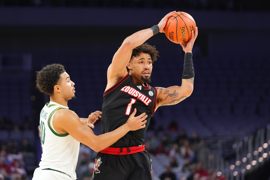 Louisville guard J'vonne Hadley (1) looks to pass the ball against Baylor guard Isaac Williams, left, during the first half of an NCAA college basketball game Saturday, Feb. 14, 2026, in Fort Worth, Texas. (AP Photo/LM Otero)