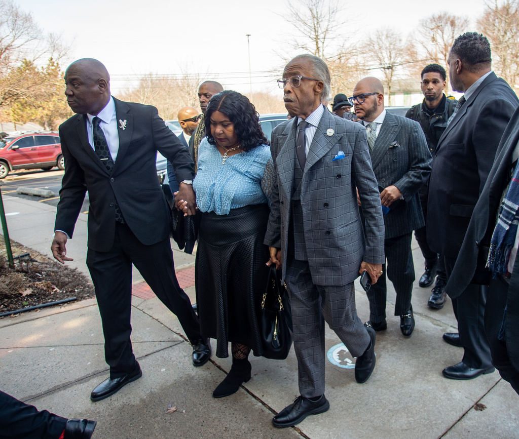 Attorney Ben Crump, left, and the Rev. Al Sharpton escort Audrey Jones, sister of Steven Jones, a man in a mental health crisis who was shot by police, into The First Cathedral for Jones's funeral service, Thursday, March 26, 2026 in Bloomfield, Conn. (Aaron Flaum/Hartford Courant via AP)