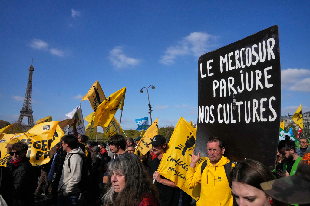 FILE - French farmers protest with a poster reading "Mercosur betrays our cultures" against the Mercosur trade alliance with South America countries Tuesday, Oct. 14, 2025 near the Eiffel Tower in Paris. (AP Photo/Michel Euler, File)