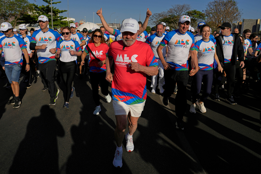 FILE - Brazil's President Luiz Inacio Lula da Silva, center, and first lady Rosangela da Silva, front left in a red jersey, take part in the 'Walk in Celebration' to mark the Ministry of Culture's 95th anniversary, in Brasilia, Brazil, Sept. 28, 2025. (AP Photo/Eraldo Peres, File)