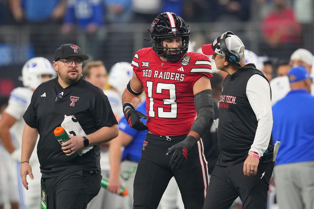 FILE -Texas Tech head coach Joey McGuire, right, talks to linebacker Ben Roberts (13) during the Big 12 Conference championship NCAA college football game against BYU, Dec. 6, 2025, in Arlington, Texas. (AP Photo/Julio Cortez, File)