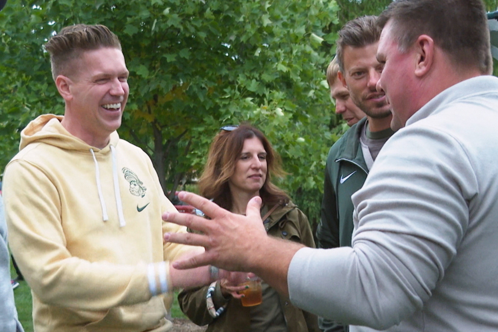In this image made from video former Sparty mascots, Ross Ramsey, far left, Phil Lator, second from right, and Scott Ferry, far right, hang out at a pregame tailgate on Michigan State University campus, Sept. 6, 2025, in East Lansing, Mich. (AP Photo/Mike Householder)